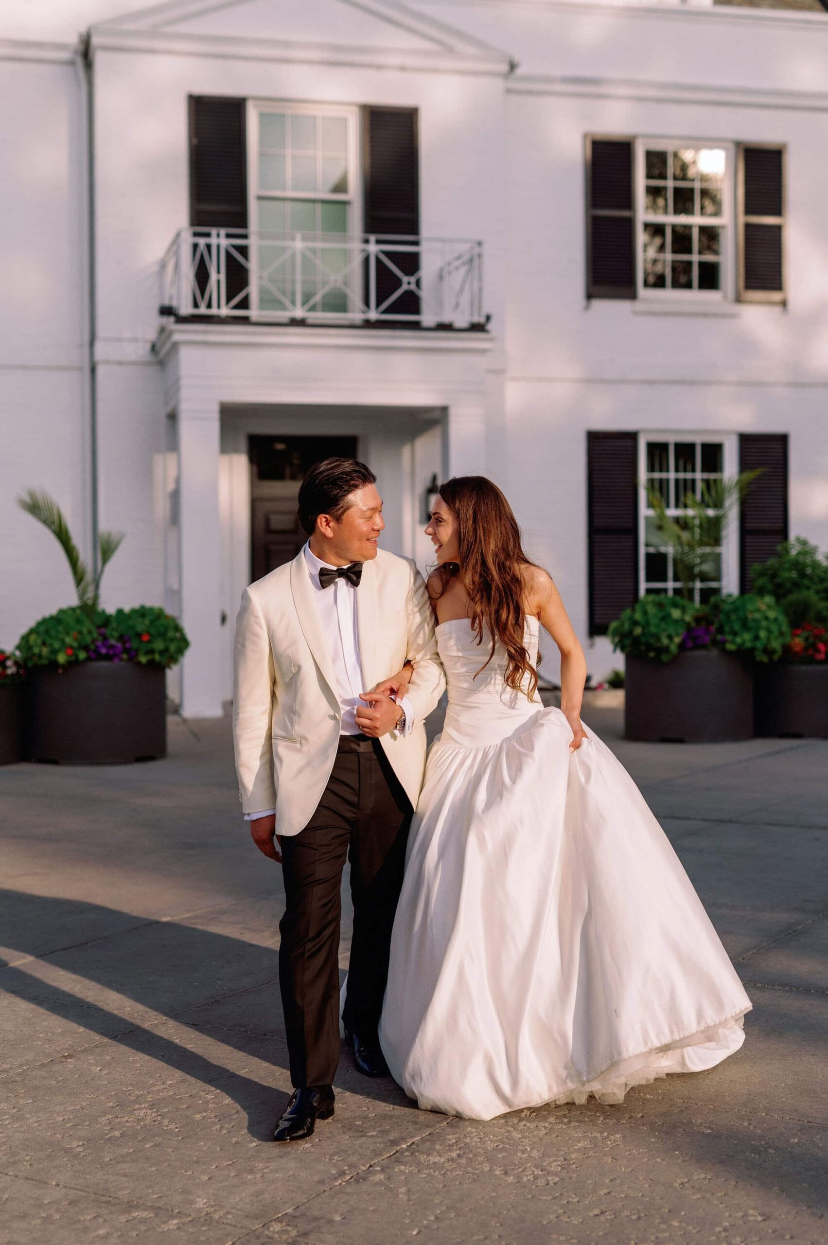 Bride and groom walking together outside Harding Waterfront Estate during their wedding in Mississauga.